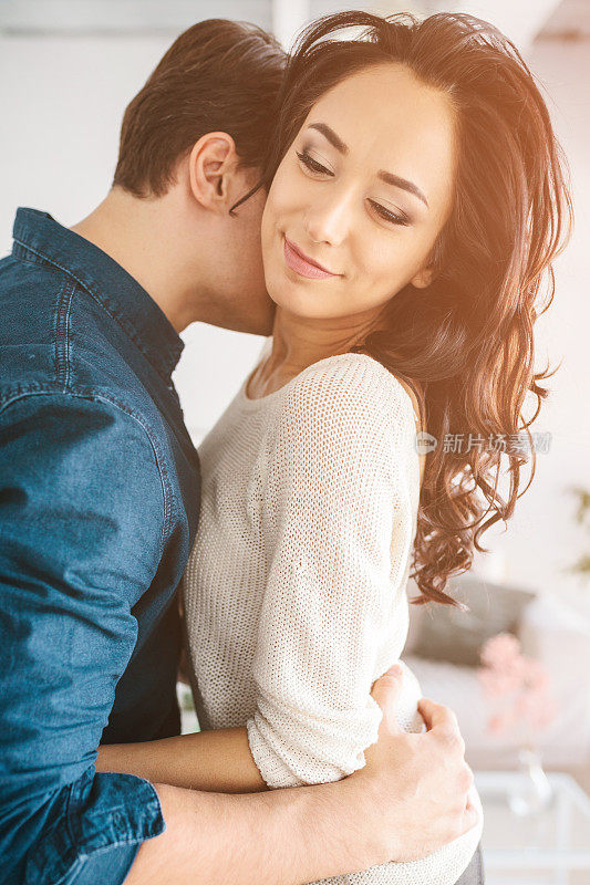 年轻漂亮的女人拥抱着一个男人。关心、可靠、爱和人与人之间的亲密关系。