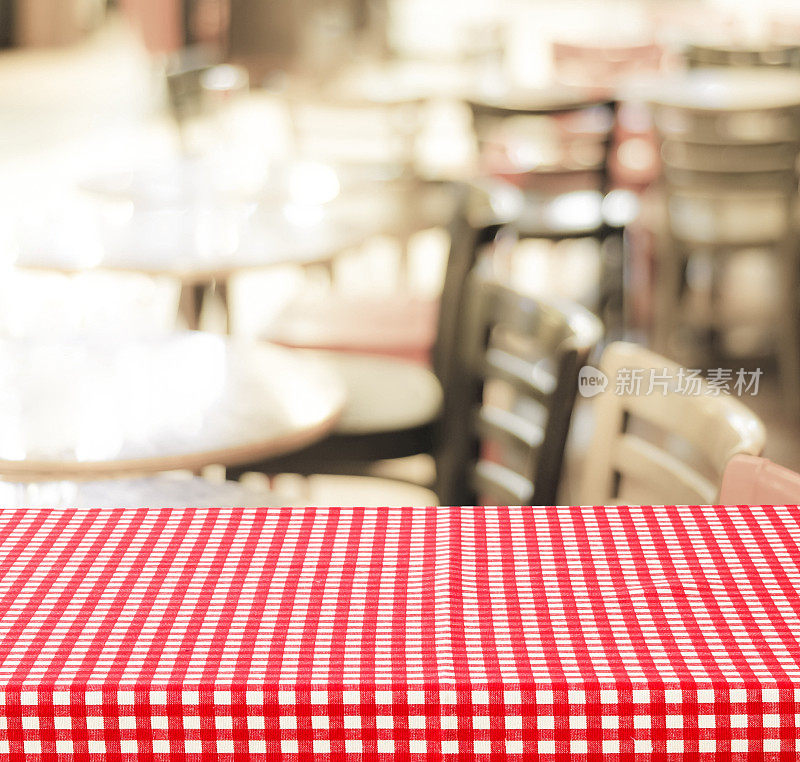 空桌子与红色格子桌布上模糊的咖啡馆与散景背景