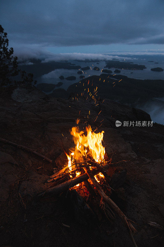 篝火的边缘与篝火上面的海湾与岛屿和森林在多云的天气在晚上从顶视图