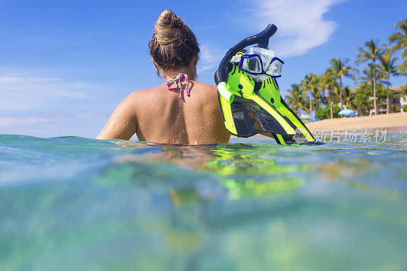 女人浮潜在海洋在一个热带岛屿度假胜地