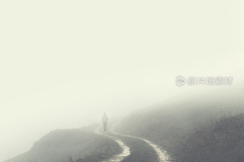 孤独的人消失在雾中