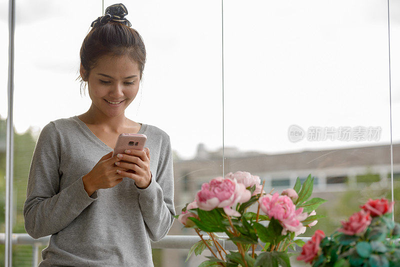 年轻美丽的亚洲女人在家里放松