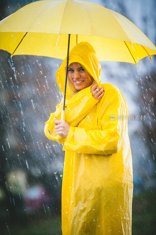 微笑美丽的女人在雨中撑着伞