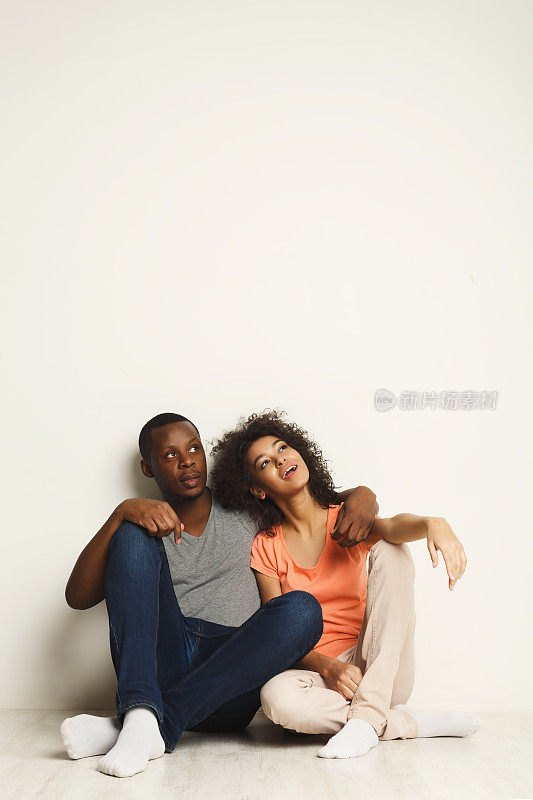 一对非裔美国人夫妇，坐在地板上