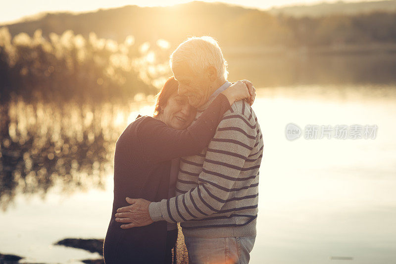 一对老年夫妇在湖边享受秋日