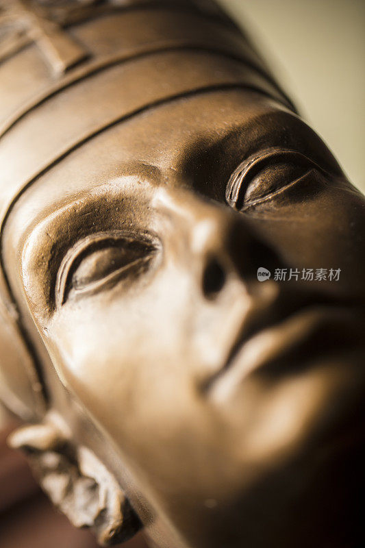 一个青铜色的娜芙提蒂半身像的特写，用石膏制成。