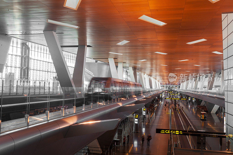 俯瞰一个现代化的机场航站楼，航站楼之间有穿梭列车