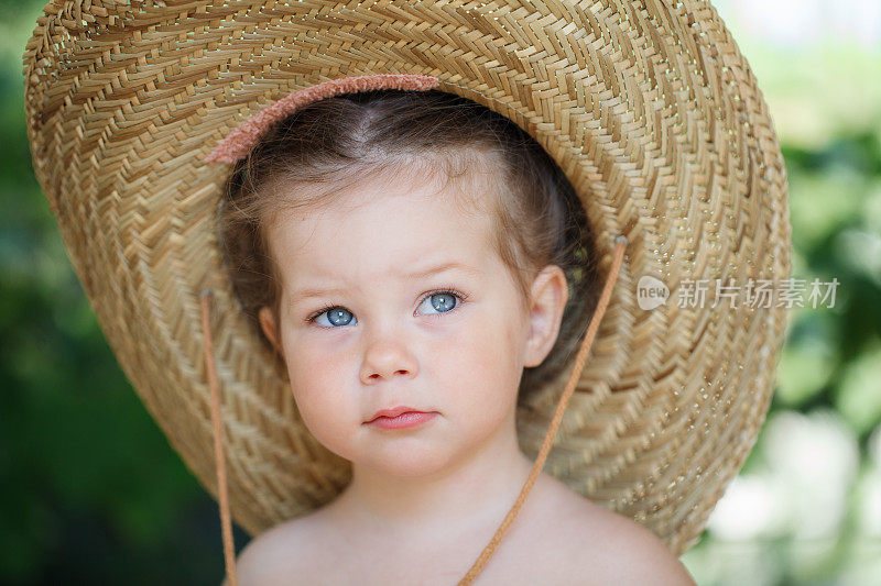 一个戴着大帽子的漂亮小女孩的肖像