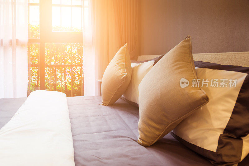 美丽的床和干净的白色枕头和床单在美丽的房间。特写镜头。阳光下的镜头。