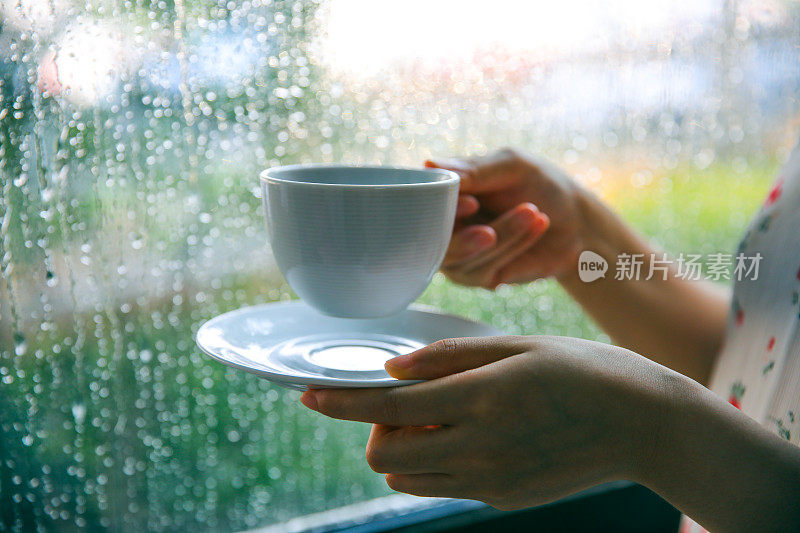 下雨天靠窗喝咖啡的女人