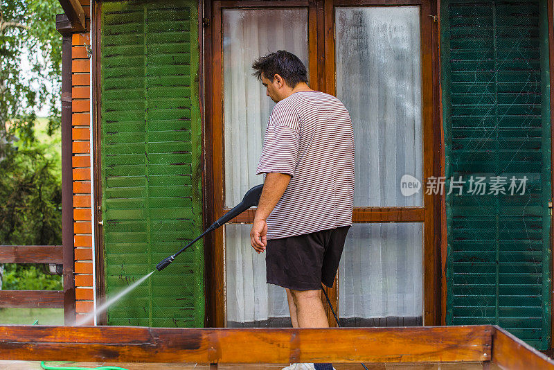 男人用喷水器清洁房屋