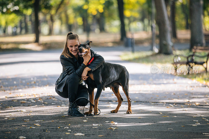女孩拥抱美丽的杜宾犬