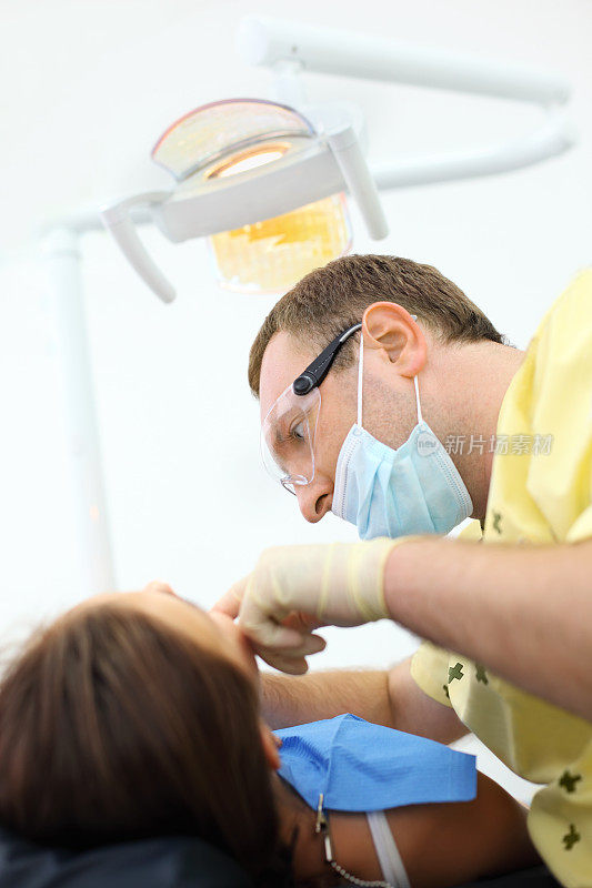 牙科医生在牙科诊所治疗女孩的牙齿。