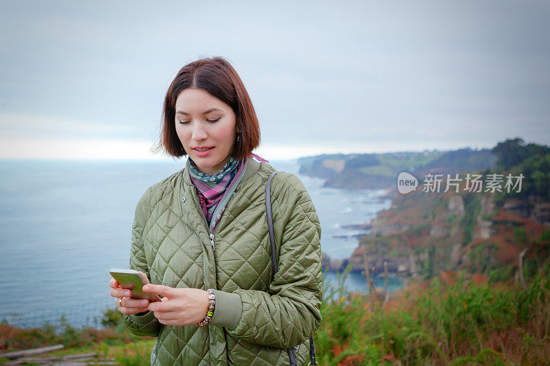 在自然环境中拿着智能手机的女人