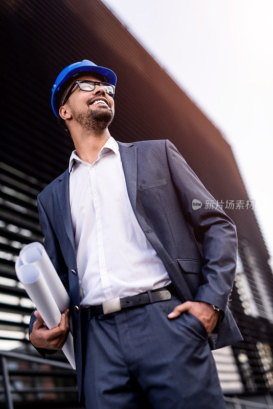 年轻的非裔美国建筑师看着建筑工地。