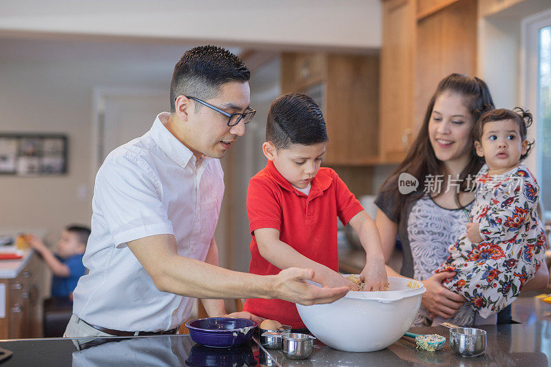 一个西班牙小男孩帮他的父母烤饼干