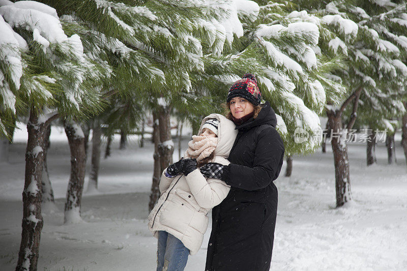 妈妈和女儿在雪中玩耍