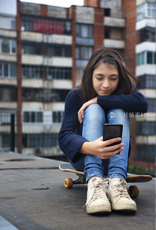 美丽的女孩滑冰用手机