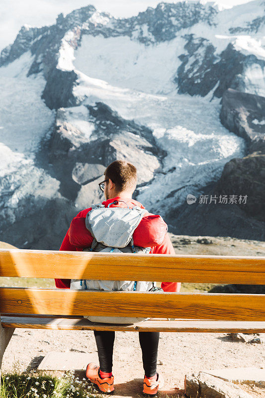 男子背包客放松与瑞士阿尔卑斯山后徒步旅行的观点