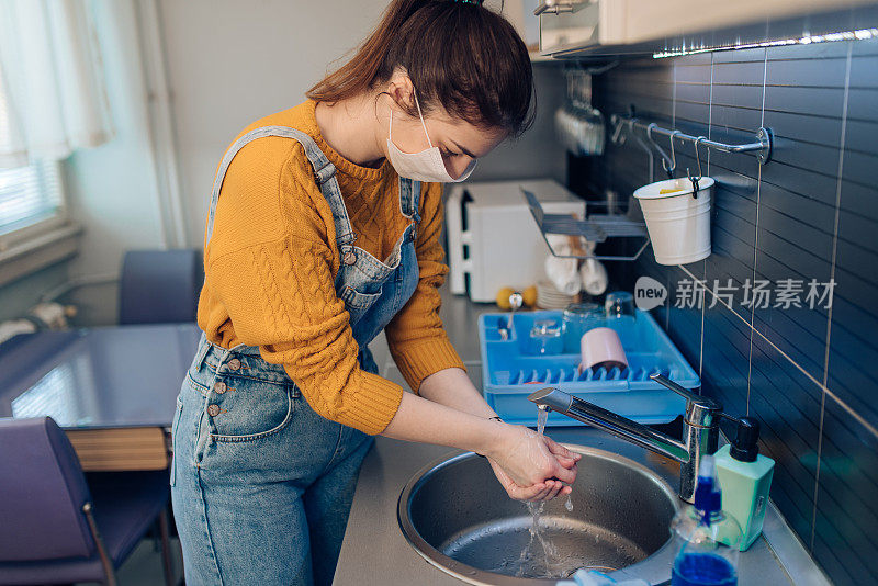 年轻女子戴防护口罩，洗手