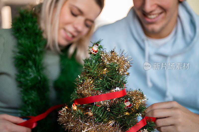 年轻夫妇在家里装饰圣诞树