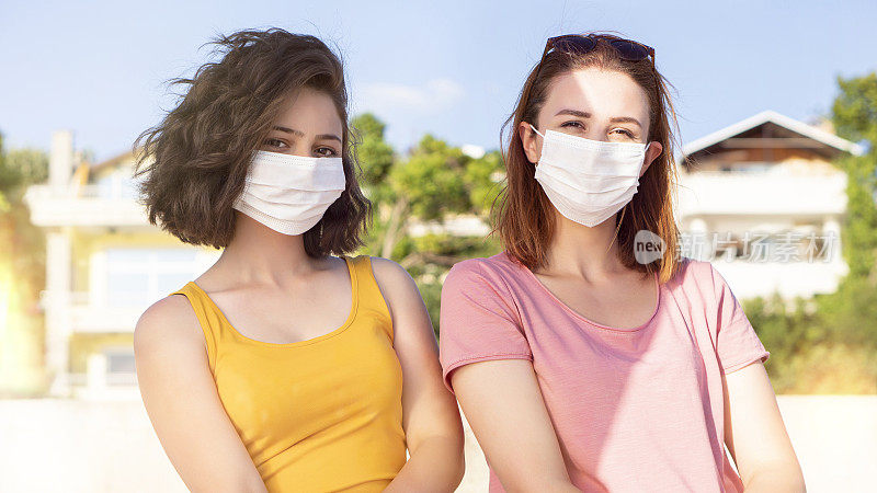 2019年新冠肺炎大流行的冠状病毒，在城市街道上的年轻女孩戴着口罩，以防止冠状病毒疾病的传播。近距离观察戴着防护口罩的年轻妇女，以预防SARS-CoV-2