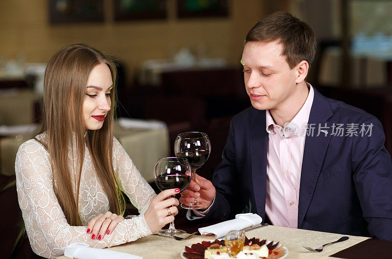 一对夫妇在一家豪华餐厅里敬酒杯。