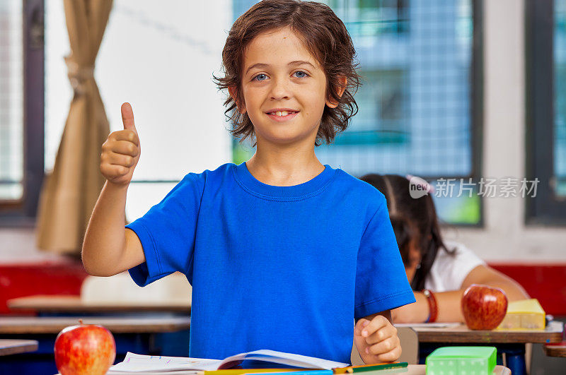 回到学校。教育的概念。阿根廷学童在课堂上竖起大拇指的肖像。开学第一天