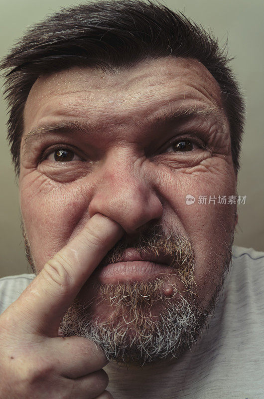 一个手指插在鼻子里的男人的不寻常的肖像。