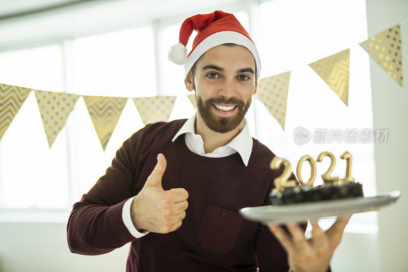 一个男人在新年派对上拿着巧克力蛋糕玩得很开心