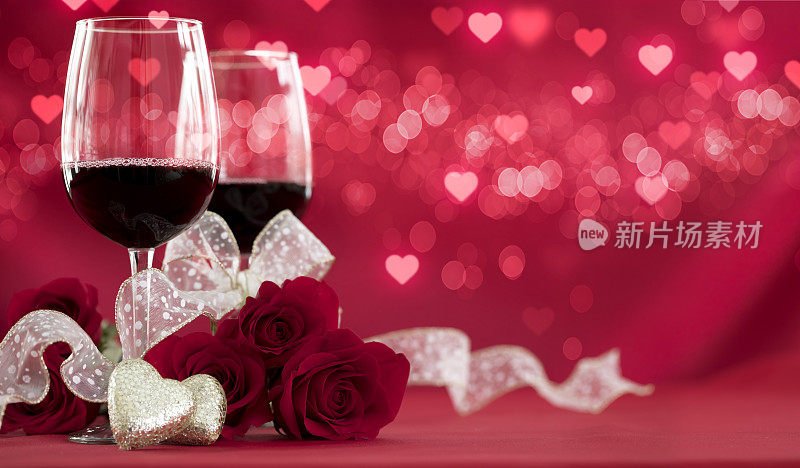 情人节的红玫瑰和红酒在散焦灯光的背景
