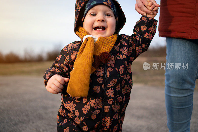 快乐的小男孩和他那认不出来的妈妈一起在大自然中行走，看着镜头