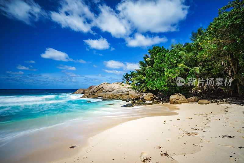 美丽的天堂般的热带海滩，棕榈树，岩石，白色的沙子，绿松石的水，塞舌尔