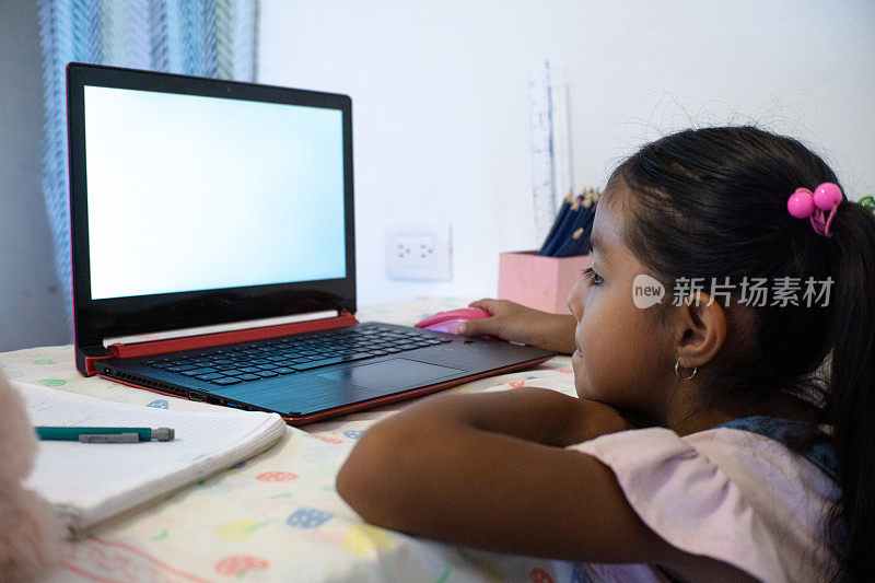 一个小女孩在家里用笔记本电脑facetime视频通话，使用在线虚拟课堂缩放，社交距离，家庭教育