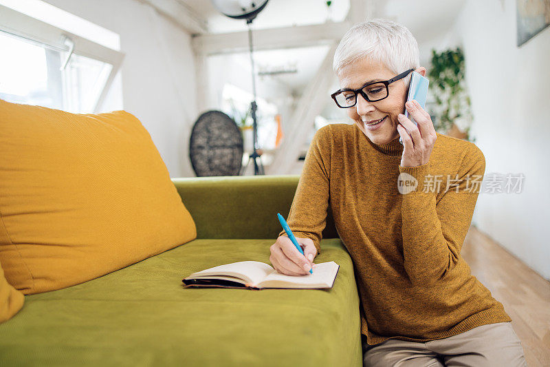 一个成熟的女人在家打商务电话