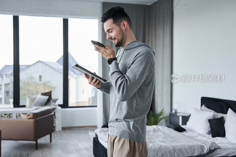 男性在卧室用智能手机录语音信息