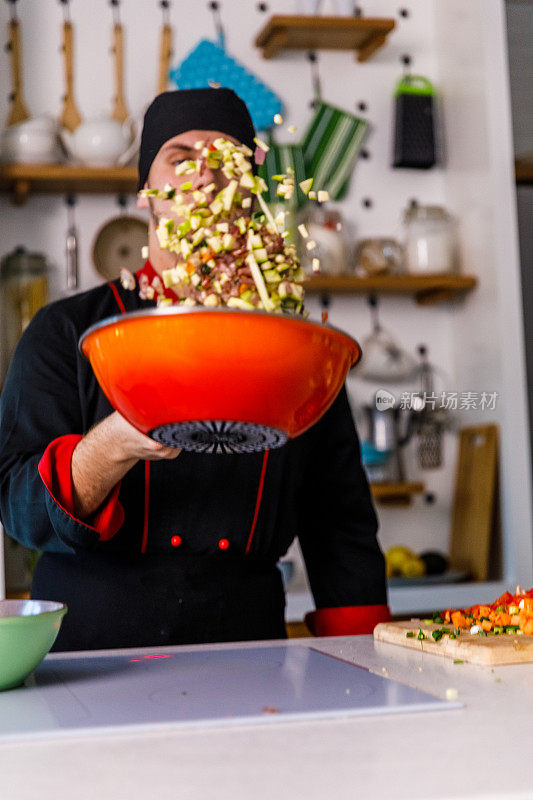 专业厨师在sautéing煮蔬菜的时候把蔬菜扔进锅里的偷拍照片