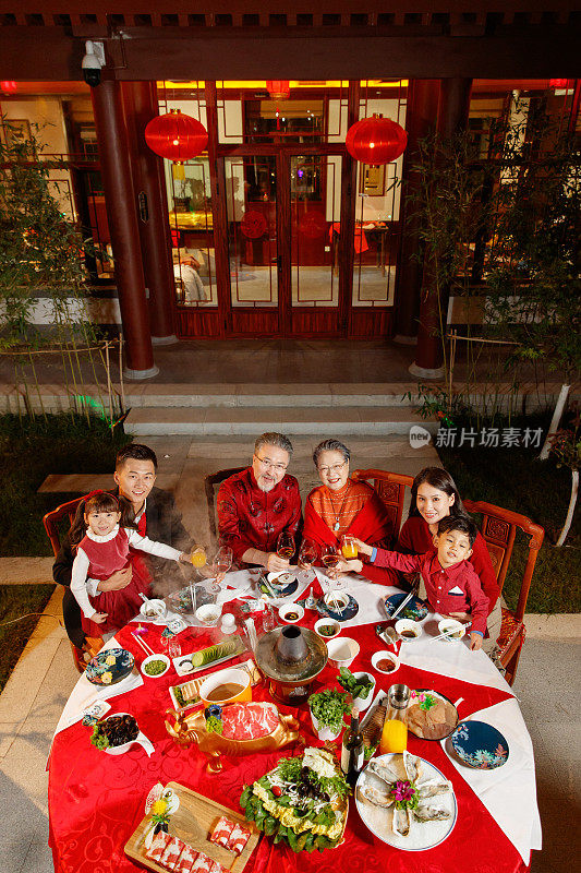 东方家庭在中式庭院内干杯庆祝新年