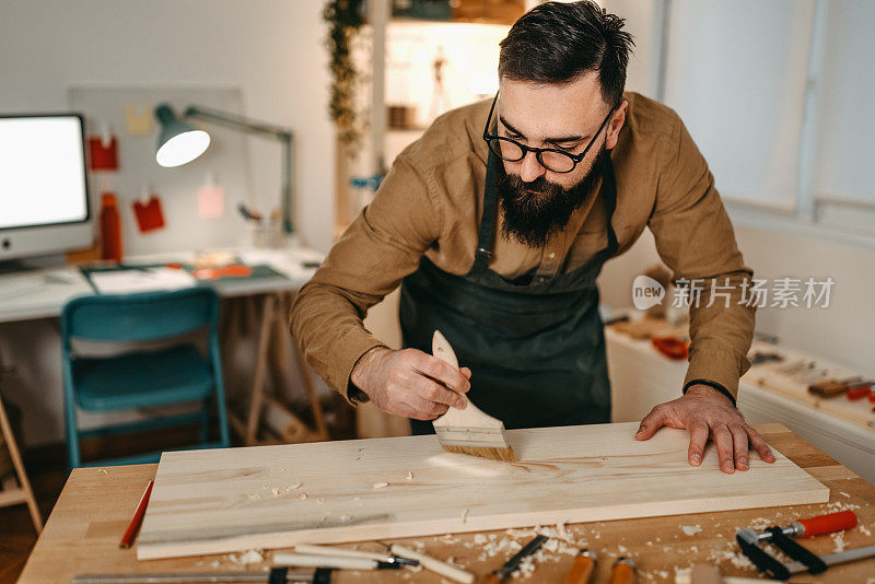 男艺术家在艺术工作室用画笔清洁木材
