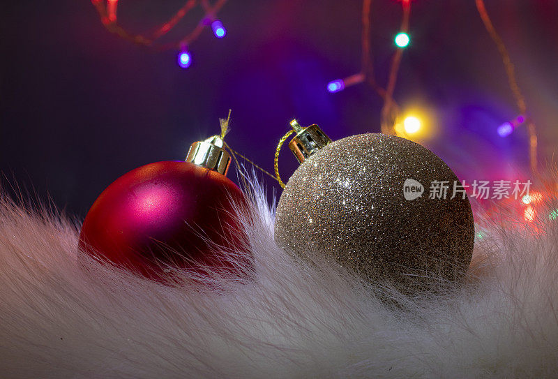 圣诞节灯泡。金色和红色球圣诞装饰在紫色的背景。