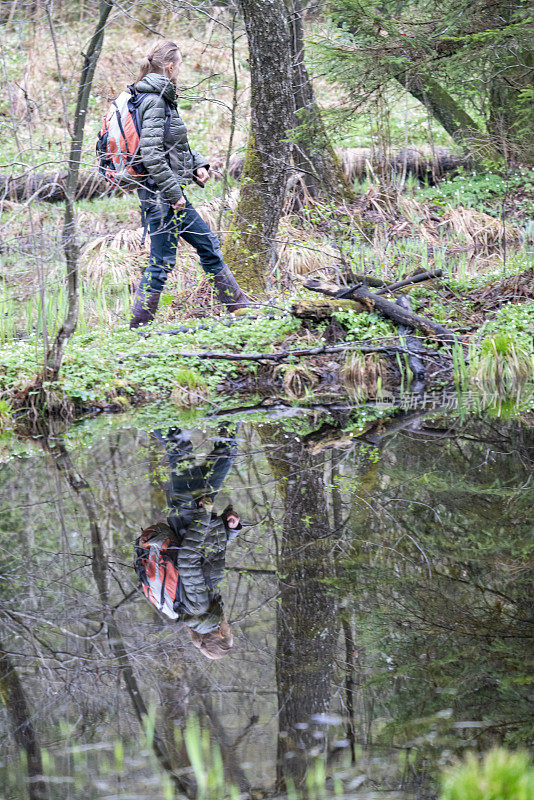 在斯洛文尼亚卢布尔雅那的巴尔杰沼泽，一位穿着靴子的老妇人在春天漫步。