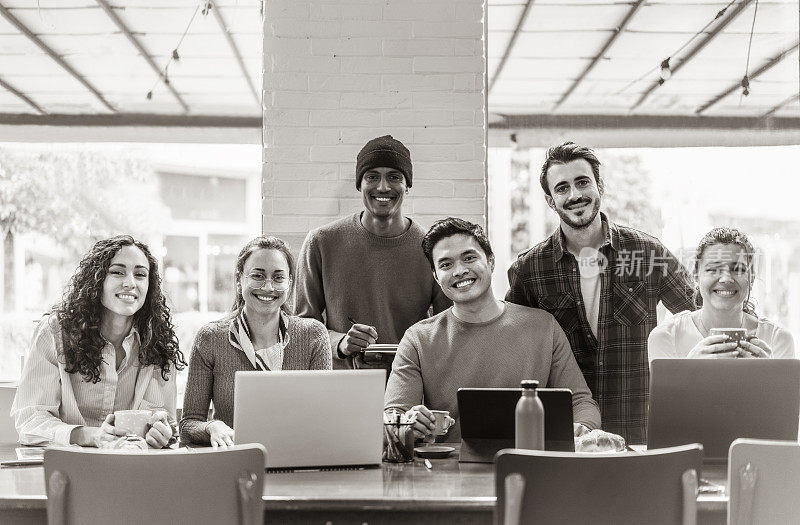 微笑的多民族同事看着相机在现代办公室一起制作团队照片-快乐的多元化工作小组或部门笑在工作场所拍照-展示团结和合作