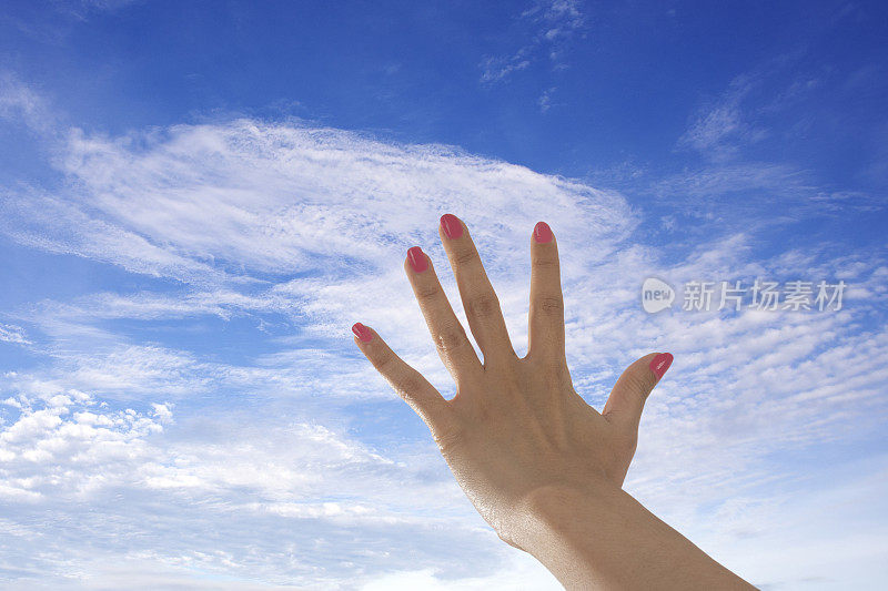 女人举起手向天空追寻希望。