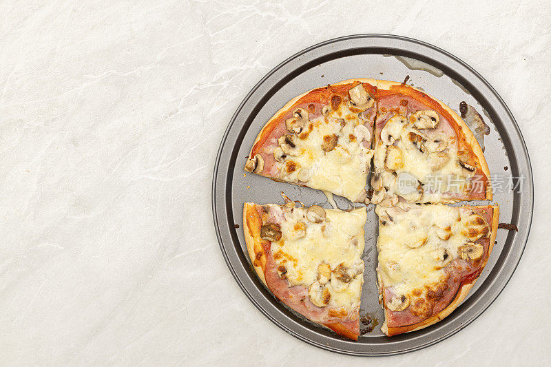 番茄酱、火腿、芝士和蘑菇的烤披萨俯视图。