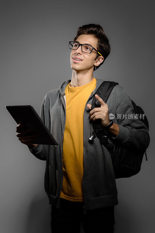年轻学生的肖像与背包和数字平板电脑
