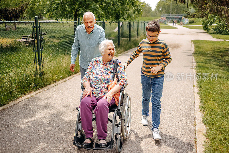 照顾轮椅上的爷爷的孩子