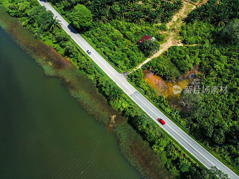 海岸线公路接近绿色森林和湖泊，从上面看。