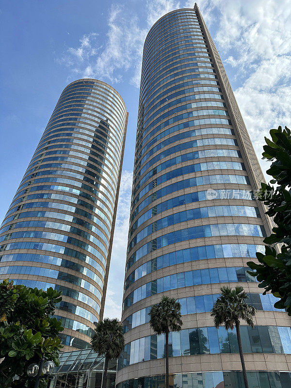 斯里兰卡科伦坡市中心世界贸易中心(WTC)双塔的特写图像，晴朗的蓝色多云天空背景，低角度视图