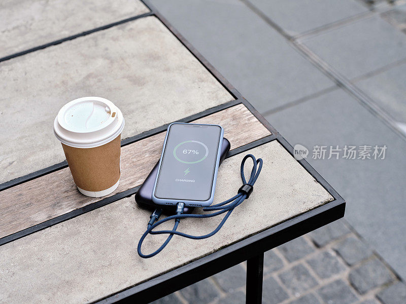 用充电宝充电的手机放在咖啡桌上