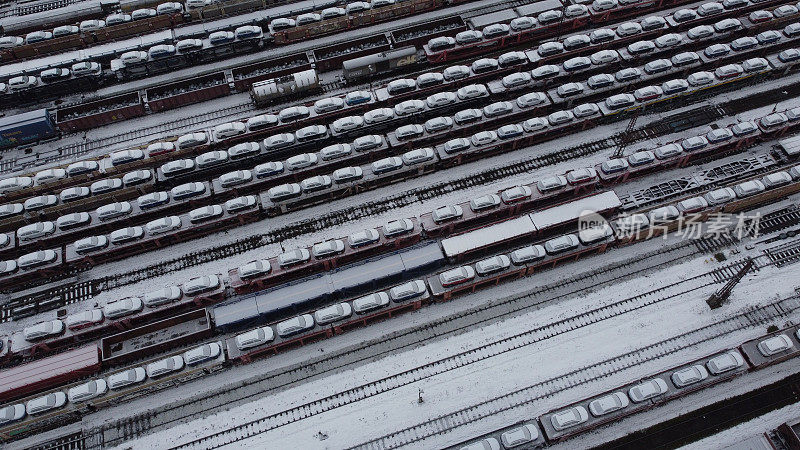 鸟瞰图，一个有多条铁路线的火车场，上面有汽车